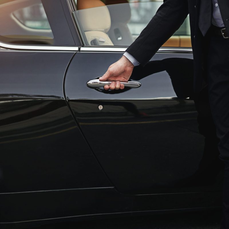 Top class transportation. Cropped shot of a well dressed man opening a car door